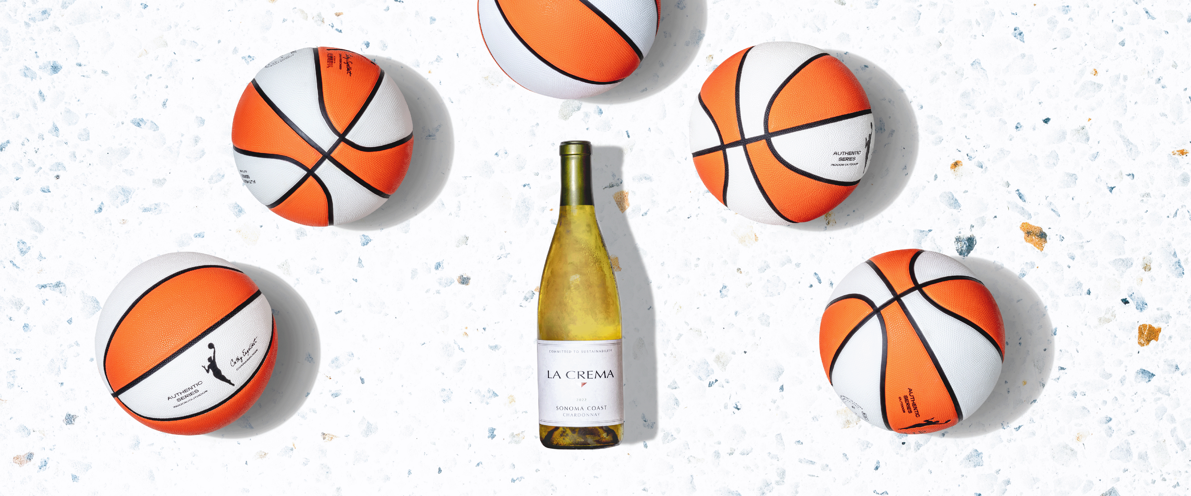 WNBA Basketballs surrounding a bottle of La Crema Chardonnay